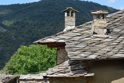 Built structure by trees and house in forest