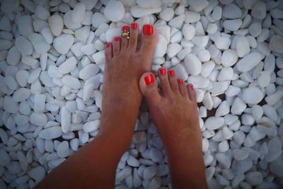 Low section of woman legs on pebbles