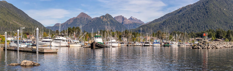 Sailboats moored in lake against sky