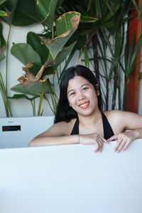 Portrait of a smiling young woman in bathtub