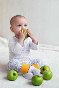 Full length of cute girl sitting on apple