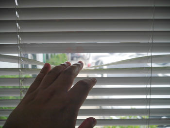 Cropped image of hand on window