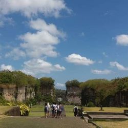 Rear view of people walking in park against sky