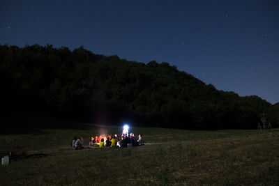 People on field against sky at night