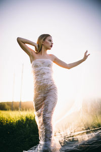 Side view of woman standing against sky