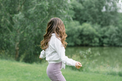 Happy girl with long wavy hair blowing in the wind in nature