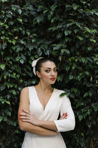 Portrait of woman standing against plants