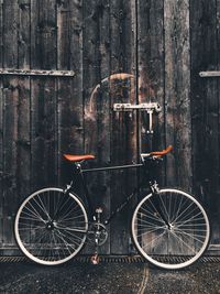 Bicycle parked against wooden planks