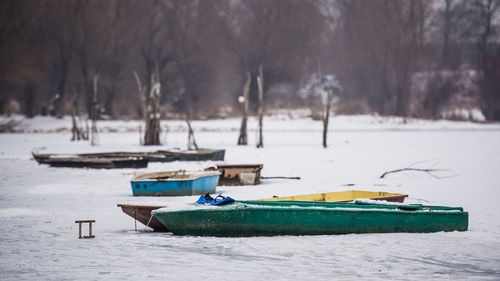 Boat moored on shore during winter