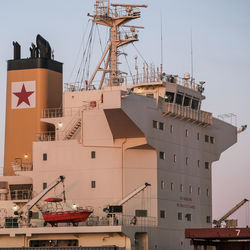 Ship moored at harbor against sky