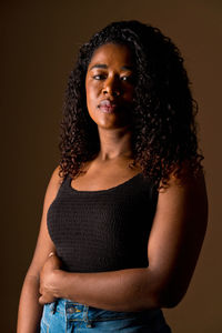 Portrait of young woman against black background