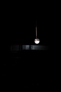 Low angle view of illuminated pendant light in darkroom