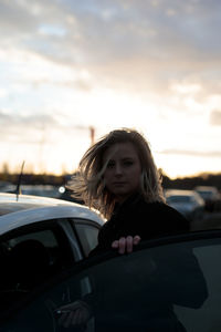Portrait of young woman looking away on car