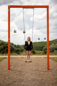 Full length portrait of young woman standing on land