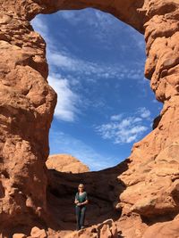 Woman standing by rock formation at arches national park