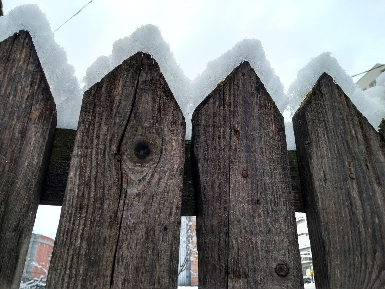 WOODEN FENCE ON SNOW COVERED LANDSCAPE