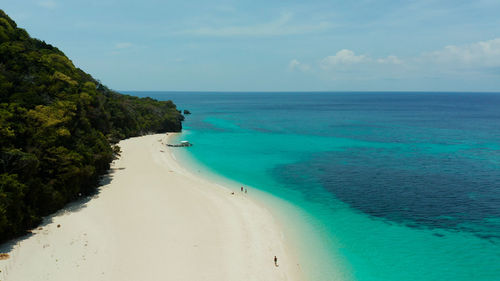 Sandy beach with palm trees and turquoise waters of the coral reef,puka shell beach. boracay