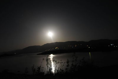 Scenic view of lake against sky at night