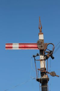 Low angle view of communications tower against clear blue sky