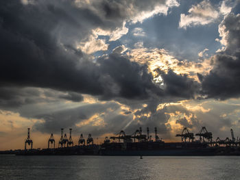 Panoramic view of commercial dock against sky during sunset