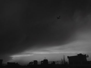 Low angle view of silhouette buildings against sky