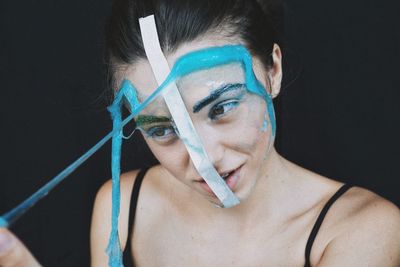 Close-up of woman with blue slime on face