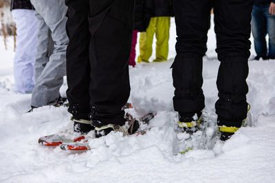 Low section of people standing in snow