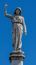 Low angle view of statue against blue sky