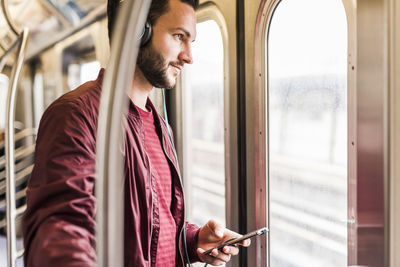Young man in subway wearing headphones