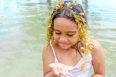Close-up of smiling young woman against lake