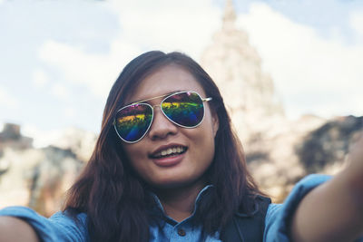 Portrait of smiling young woman wearing sunglasses