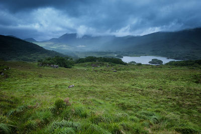 Scenic view of field and mountains against sky