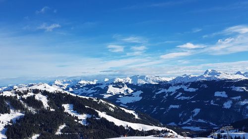 Scenic view of snowcapped mountains against blue sky