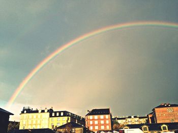 Low angle view of rainbow over buildings