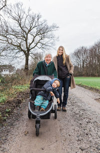 Portrait of family standing on dirt road during winter