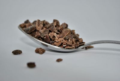 Close-up of bread in plate on table against white background