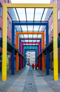 People walking on footpath amidst buildings in city