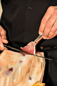 Professional cutting slices of ham and taking it with tweezers. typical spanish.