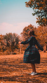 Rear view of woman standing on field