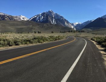 Empty road amidst landscape leading towards mountains