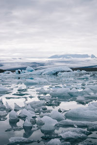 Icebergs on jokulsarlon lake against cloudy sky