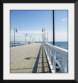 Close-up of railing by sea against sky