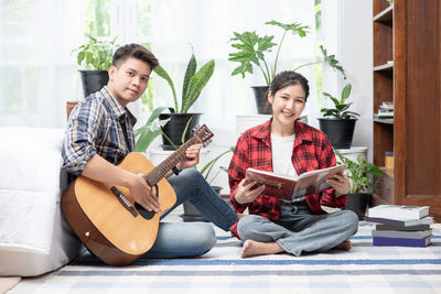 Young couple sitting on guitar