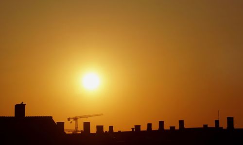 Silhouette buildings against clear sky during sunset