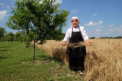 Portrait of smiling young woman standing on field