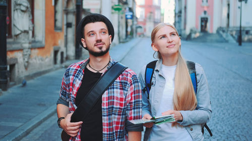 Portrait of smiling couple standing in city