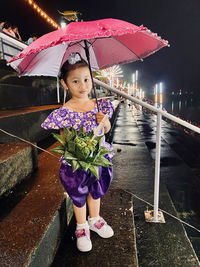 Full length of cute girl standing on rainy day