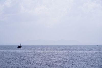 Sailboat sailing on sea against sky