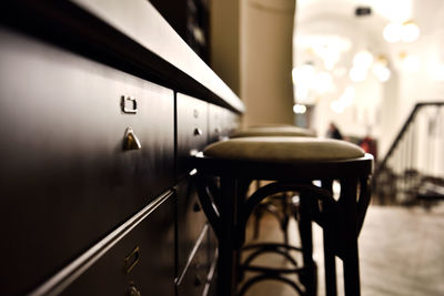 Close-up of stools by cabinet