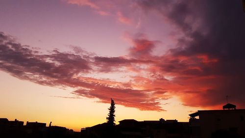 Low angle view of buildings against dramatic sky